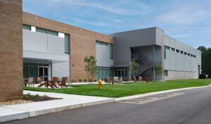 Exterior architectural photograph of the Emergency Response Training Facility showing modern brick and corrugated metal facade, manicured lawn, and outdoor patio by Dwayne Hickson, Graphic Productions in Oak Ridge, TN.