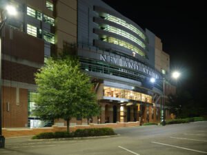 Architectural night photograph of illuminated Neyland Stadium west facade and Shields-Watkins Field signage at UTK in Knoxville, TN.