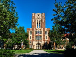 Architectural photograph of historic Ayres Hall clock tower naturally framed by green trees on The Hill at UTK in Knoxville, TN.