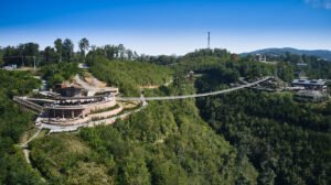 High aerial drone photograph of Gatlinburg SkyPark amphitheater and the SkyBridge suspension span over a forested mountain ravine by Dwayne Hickson, Graphic Productions in Gatlinburg, TN.