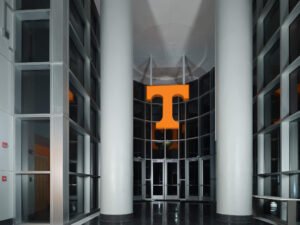 Symmetrical architectural interior view of the Brenda Lawson Athletic Center entrance rotunda and illuminated orange Power T by Dwayne Hickson, Graphic Productions in Knoxville, TN.
