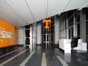 Commercial interior photograph of Brenda Lawson Athletic Center reception desk, orange branding, and Power T atrium by Dwayne Hickson, Graphic Productions in Knoxville, TN.