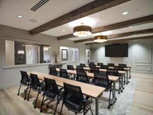 Commercial interior photograph of an executive classroom with rows of training tables, interior observation windows, and rustic ceiling beams by Dwayne Hickson, Graphic Productions in Knoxville, TN.
