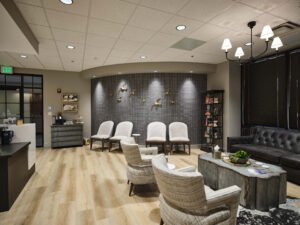 Commercial interior photograph of an executive reception lobby featuring a curved accent wall with brass birds, tufted leather sofa, and modern armchairs by Dwayne Hickson, Graphic Productions in Knoxville, TN.