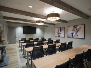 Commercial interior photograph of a modern corporate seminar room featuring tiered wood desks, rustic ceiling beams, and brass lighting by Dwayne Hickson, Graphic Productions in Knoxville, TN.