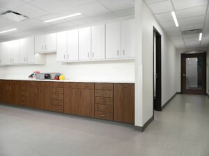 Commercial interior view of custom medical casework, wood-grain cabinets, and corridor at KOC Surgery Center in Knoxville, TN.